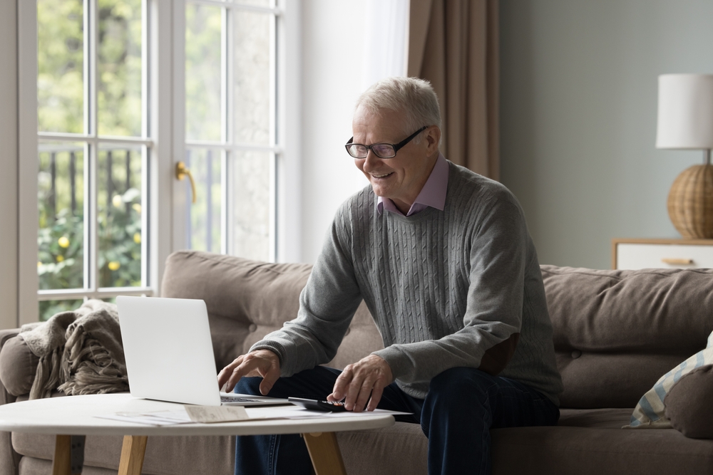 Happy,Elderly,Man,In,Glasses,Sits,On,Couch,Pay,Utility